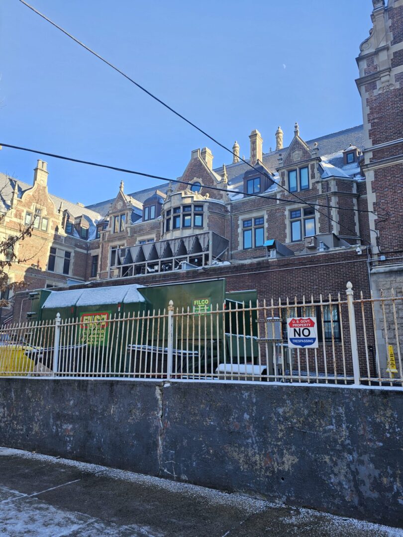 A building with many windows and some white fences