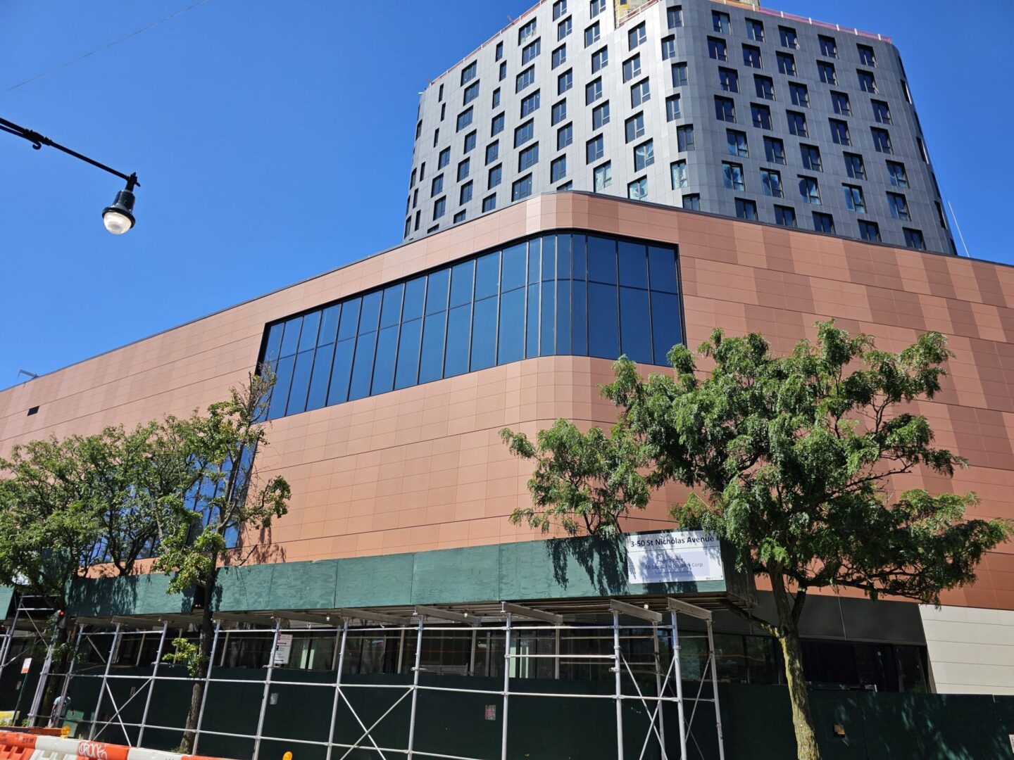 A building with a large window and trees in front of it.